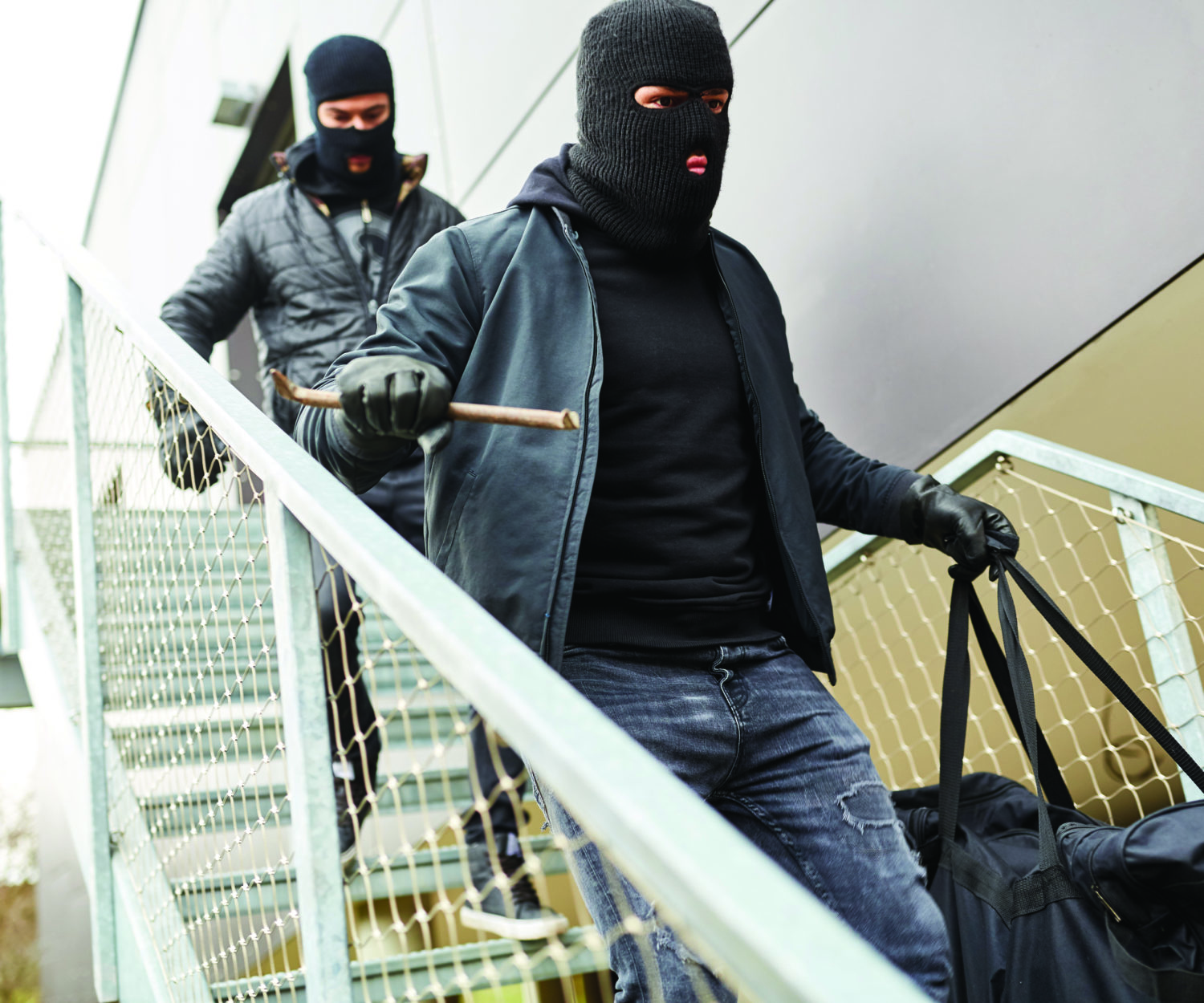 Two hooded burglars flee with booty on stairs